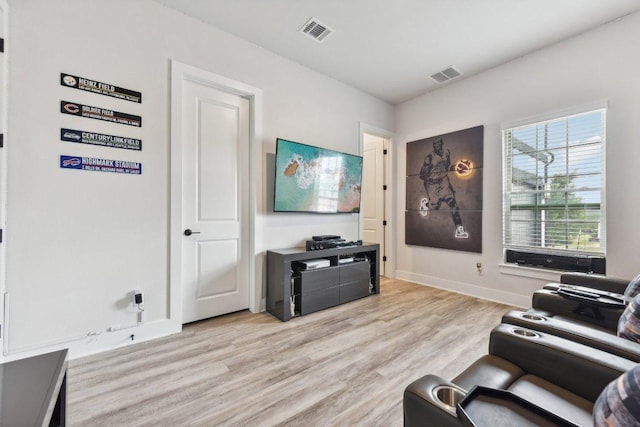 living room with baseboards, light wood finished floors, and visible vents