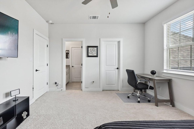carpeted office with baseboards, plenty of natural light, a ceiling fan, and visible vents
