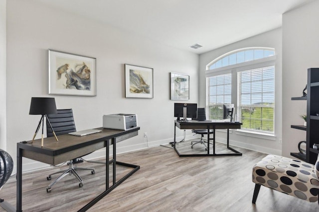 office space with baseboards, visible vents, plenty of natural light, and wood finished floors