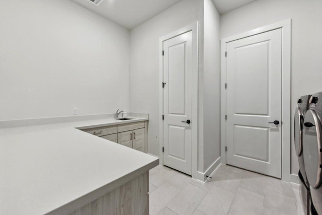 laundry area featuring a sink, cabinet space, and washing machine and clothes dryer