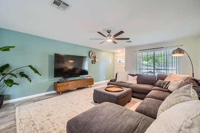 living area with baseboards, ceiling fan, wood finished floors, and visible vents