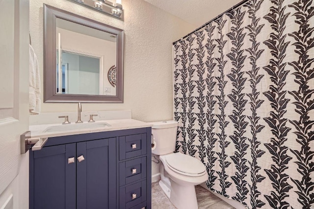 full bathroom with toilet, a textured wall, and vanity