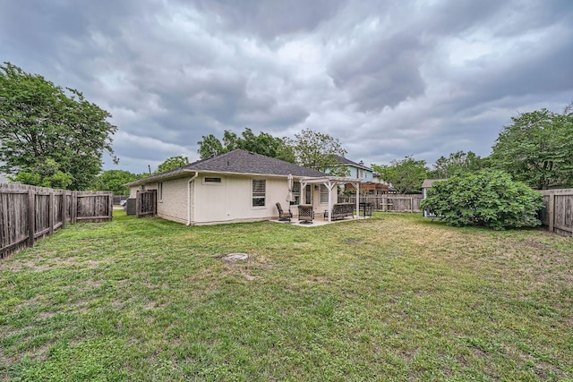 rear view of property featuring a fenced backyard, a patio area, and a yard