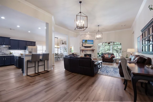 1312 Becca Teal Pl, Round Rock, TX 78681 - living area featuring a chandelier, wood finished floors, a premium fireplace, recessed lighting, and crown molding