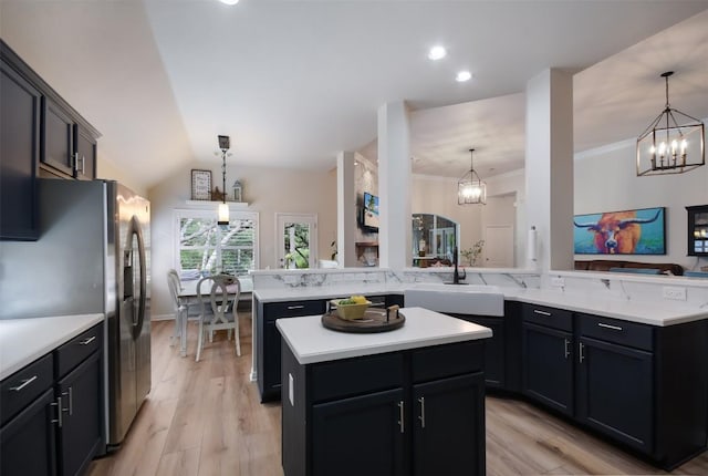 1312 Becca Teal Pl, Round Rock, TX 78681 - kitchen with freestanding refrigerator, a kitchen island, a chandelier, a sink, and light wood-style flooring