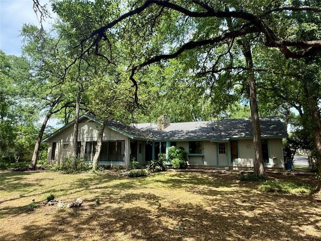 ranch-style house featuring a chimney and a sunroom