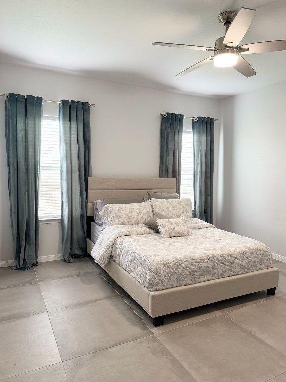 bedroom with a ceiling fan and baseboards