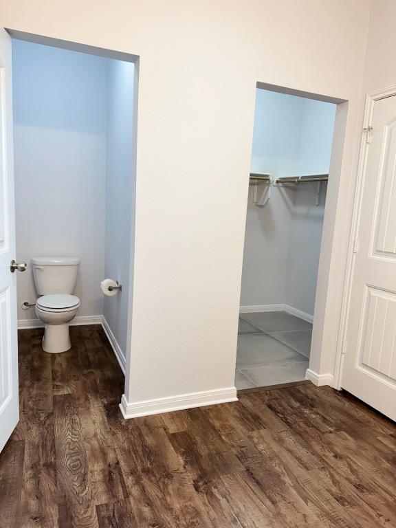 1045 Gaelic Dr, Georgetown, TX 78626 - bathroom featuring wood finished floors and a walk in closet
