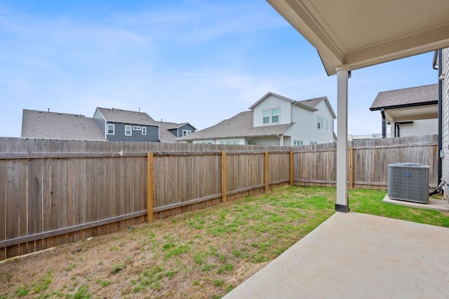 view of yard featuring a patio, a fenced backyard, central air condition unit, and a residential view