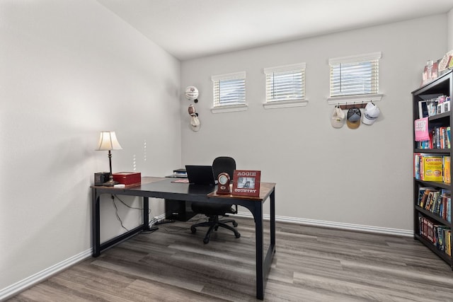 office space with baseboards, wood finished floors, and a wealth of natural light