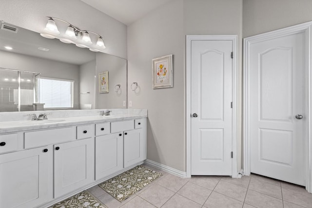 bathroom with visible vents, a sink, tile patterned flooring, and double vanity