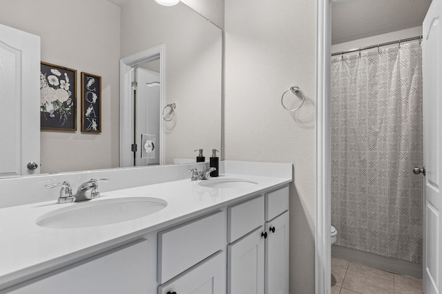 full bath featuring a sink, tile patterned floors, toilet, and double vanity