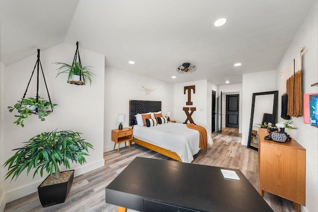 bedroom with light wood-style floors, baseboards, and recessed lighting