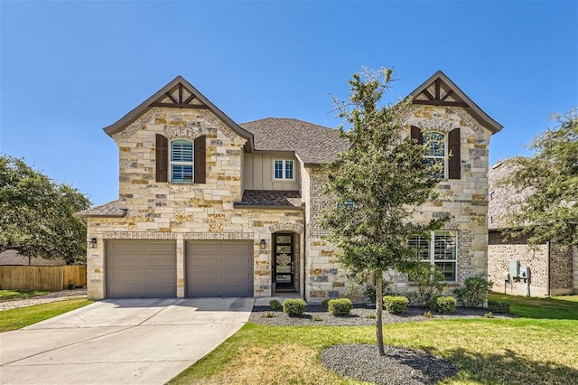 6914 Halesboro Dr, Austin, TX 78736 - view of front of property featuring an attached garage, driveway, a front lawn, and stone siding
