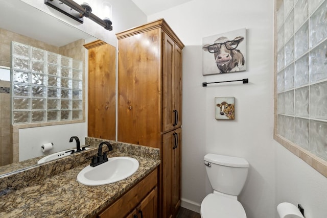 bathroom featuring toilet, baseboards, and vanity