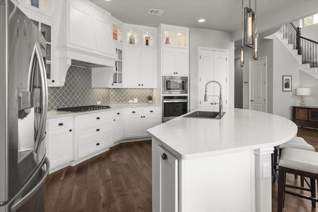 kitchen featuring dark wood-style floors, a sink, stainless steel appliances, recessed lighting, and custom exhaust hood