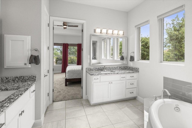 bathroom with a washtub, two vanities, a sink, and ensuite bathroom