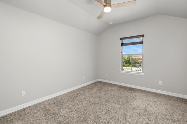 spare room featuring baseboards, a ceiling fan, carpet, and vaulted ceiling