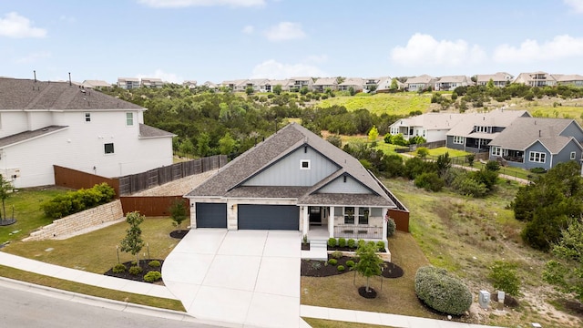 view of front facade with fence, a residential view, an attached garage, board and batten siding, and driveway