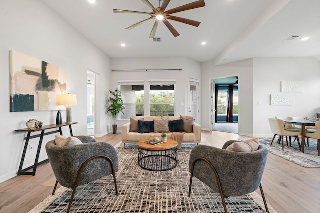 living area featuring a ceiling fan, baseboards, and light wood-type flooring