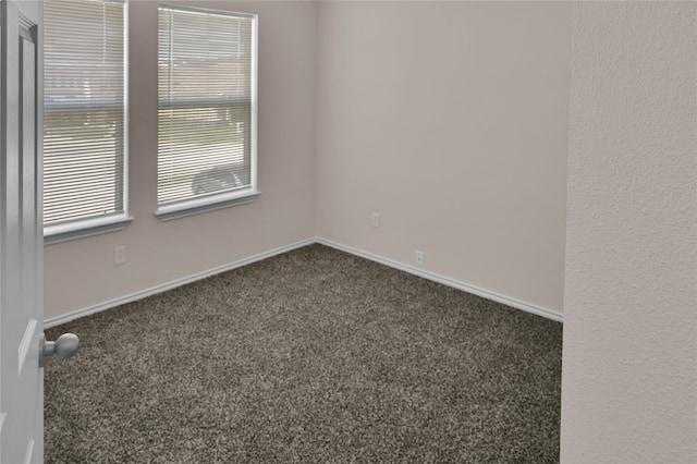unfurnished room featuring baseboards and carpet