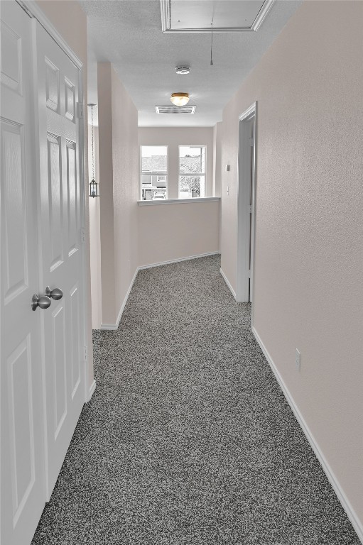 hall featuring baseboards and attic access