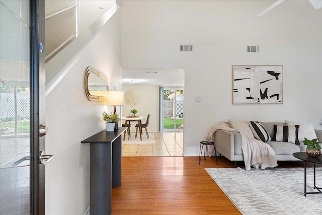 foyer with a high ceiling, wood finished floors, and visible vents