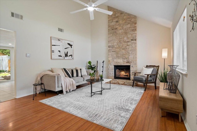 living room with a ceiling fan, high vaulted ceiling, visible vents, and wood finished floors