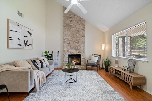 living room with ceiling fan, a fireplace, wood finished floors, and visible vents