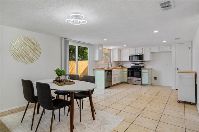 dining space with visible vents, recessed lighting, a textured ceiling, and light tile patterned floors