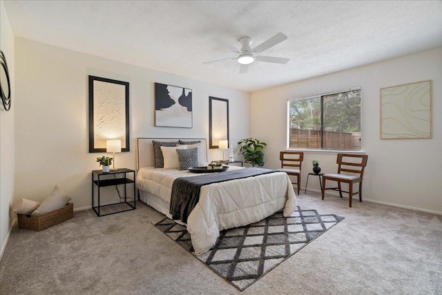carpeted bedroom with baseboards, ceiling fan, and a textured ceiling