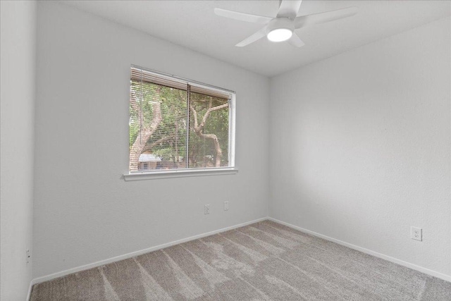 spare room with baseboards, light colored carpet, and ceiling fan