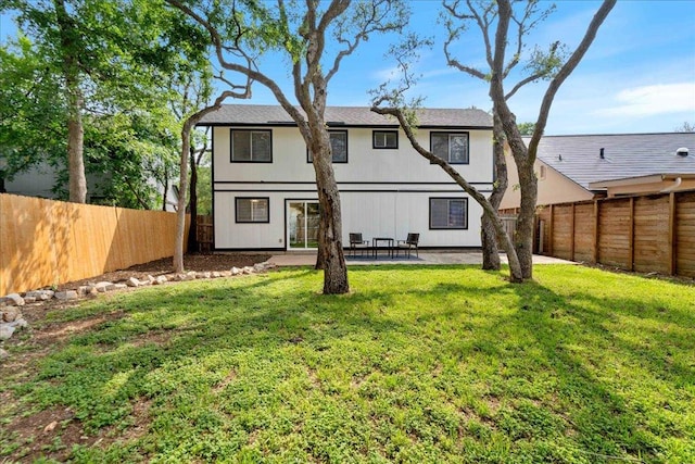 rear view of house with a patio, a fenced backyard, and a yard