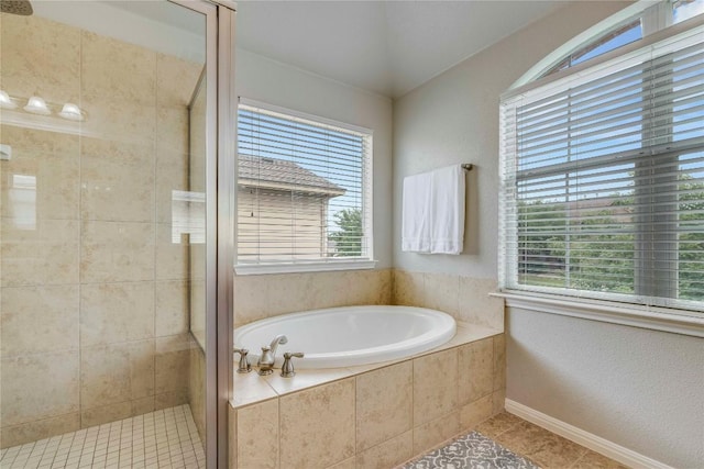 bathroom featuring tile patterned flooring, a shower stall, and a bath