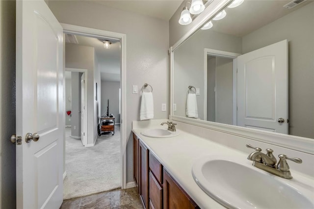bathroom featuring double vanity, baseboards, visible vents, and a sink