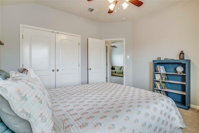bedroom featuring visible vents, a ceiling fan, a closet, and light colored carpet