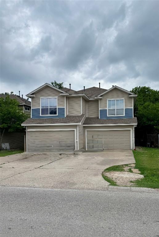 view of front of house featuring a garage, roof with shingles, and driveway