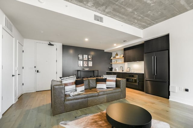 living area with visible vents, recessed lighting, light wood-style floors, and baseboards