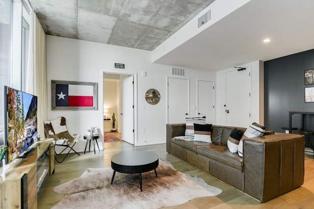 living area with visible vents and wood finished floors