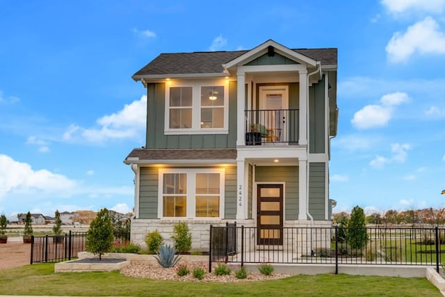 contemporary house featuring board and batten siding, fence, a balcony, and a front yard
