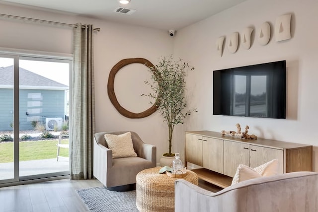 living area featuring light wood-type flooring and visible vents