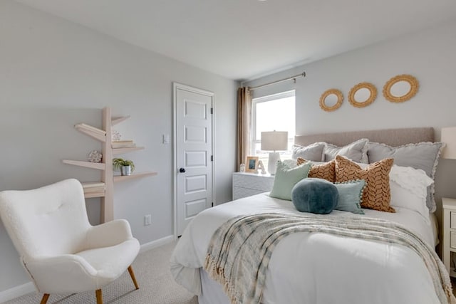 bedroom with baseboards and light carpet