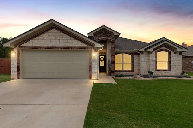 ranch-style house with concrete driveway, a front lawn, stone siding, and a garage