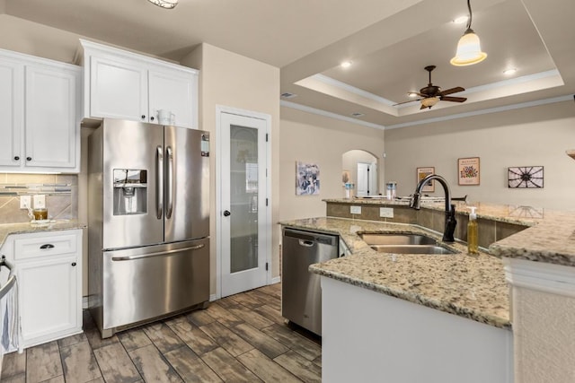 kitchen featuring a ceiling fan, crown molding, a sink, white cabinets, and stainless steel appliances