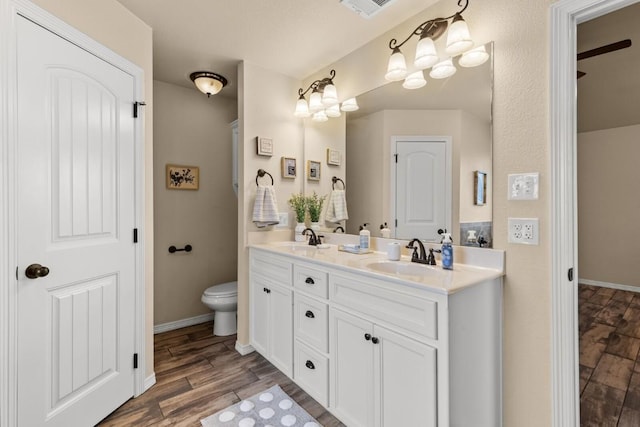 full bath with double vanity, baseboards, a sink, and wood finished floors