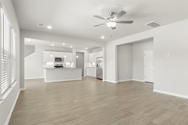 18305 Emu Ln, Manor, TX 78653 - unfurnished living room featuring healthy amount of natural light, ceiling fan, light wood-style flooring, and recessed lighting