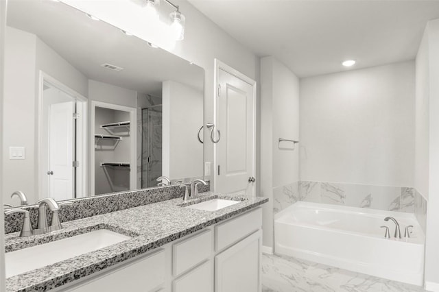 18305 Emu Ln, Manor, TX 78653 - bathroom featuring a garden tub, double vanity, a spacious closet, marble finish flooring, and recessed lighting