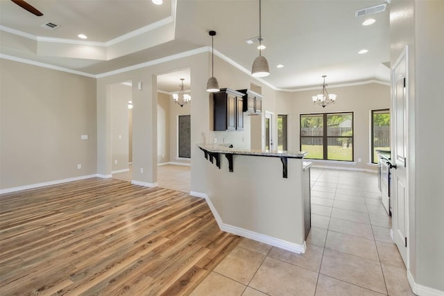 kitchen with a breakfast bar area, a chandelier, and visible vents