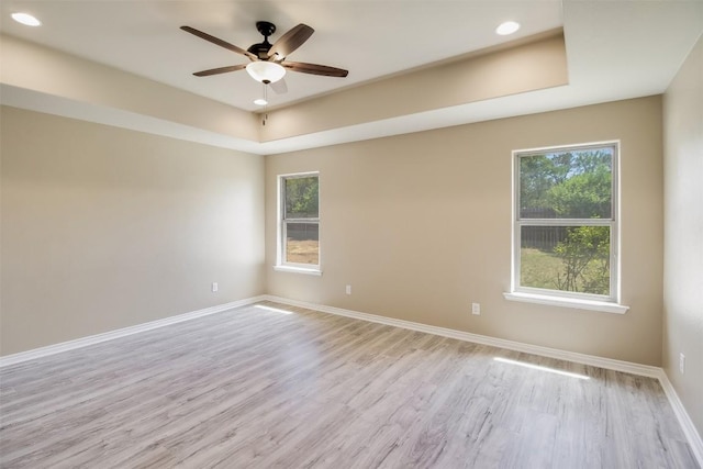 unfurnished room featuring a ceiling fan, baseboards, plenty of natural light, and light wood-type flooring