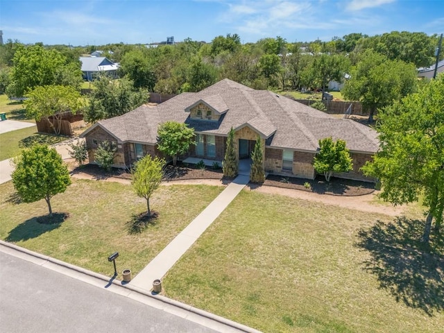 view of front of home with a shingled roof and a front yard